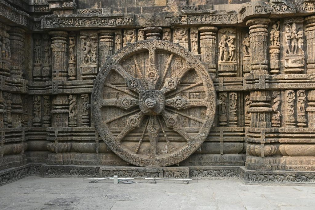 Detailed view of a carved stone wheel at Konark Sun Temple, showcasing ancient Indian art.