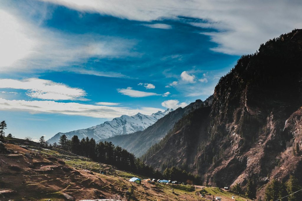 Breathtaking view of the Himalayan mountains in Himachal Pradesh, showcasing lush green forests and clear skies.