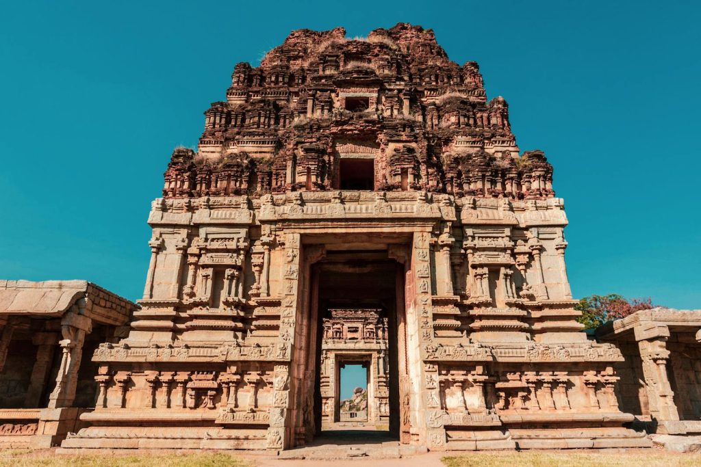 Explore the stunning stone-carved facade of a historic temple in Hampi, a UNESCO World Heritage Site.