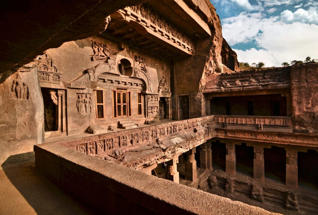 Explore the intricate rock-cut architecture of an ancient cave temple with exquisite carvings.