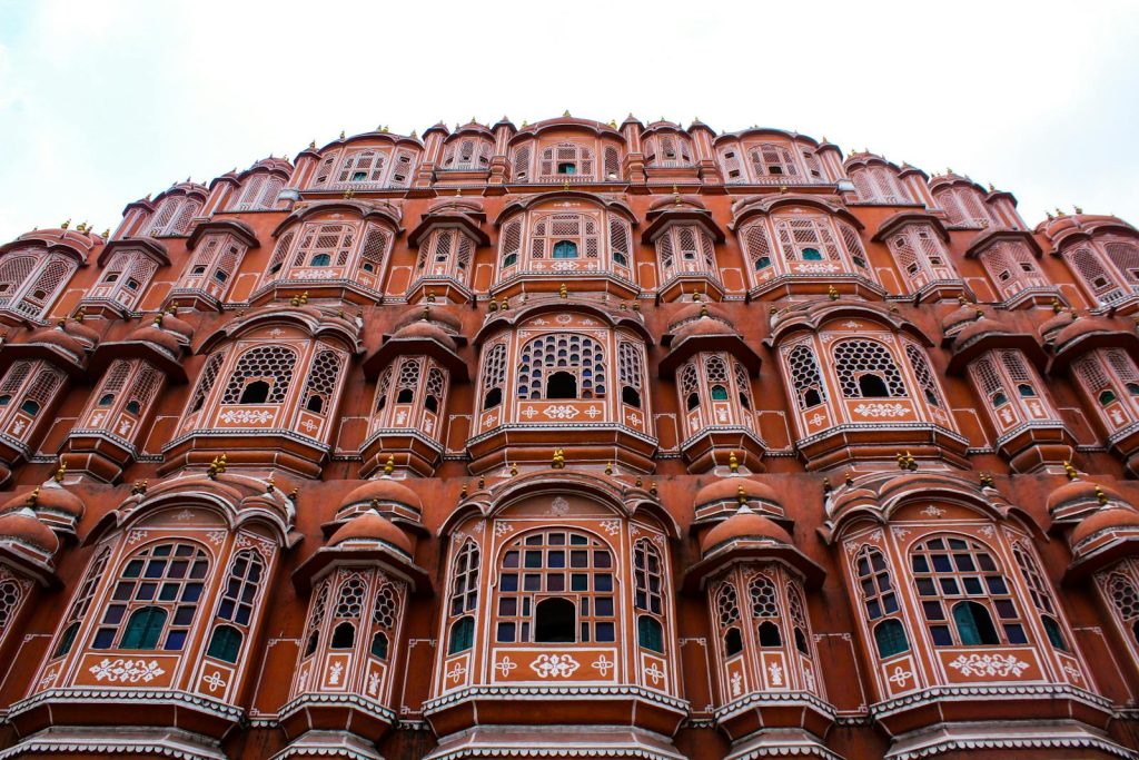 Low angle view of the iconic Hawa Mahal showcasing its elaborate facade in Jaipur, India.